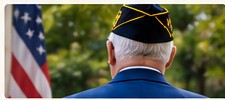 Veteran in uniform beside the American flag